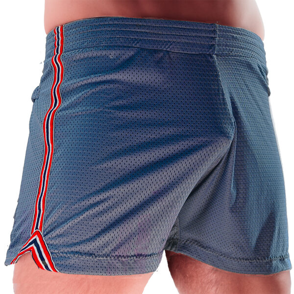 Close-up of a person wearing WOOF Freeball Mesh Field Shorts, Athletic Fit (Navy) with red and white striped trim, focusing on the bulge enhancement.