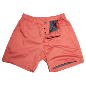 A pair of coral pink men's shorts with bulge enhancement, buttoned waist, and decorative pockets, displayed flat on a white background.